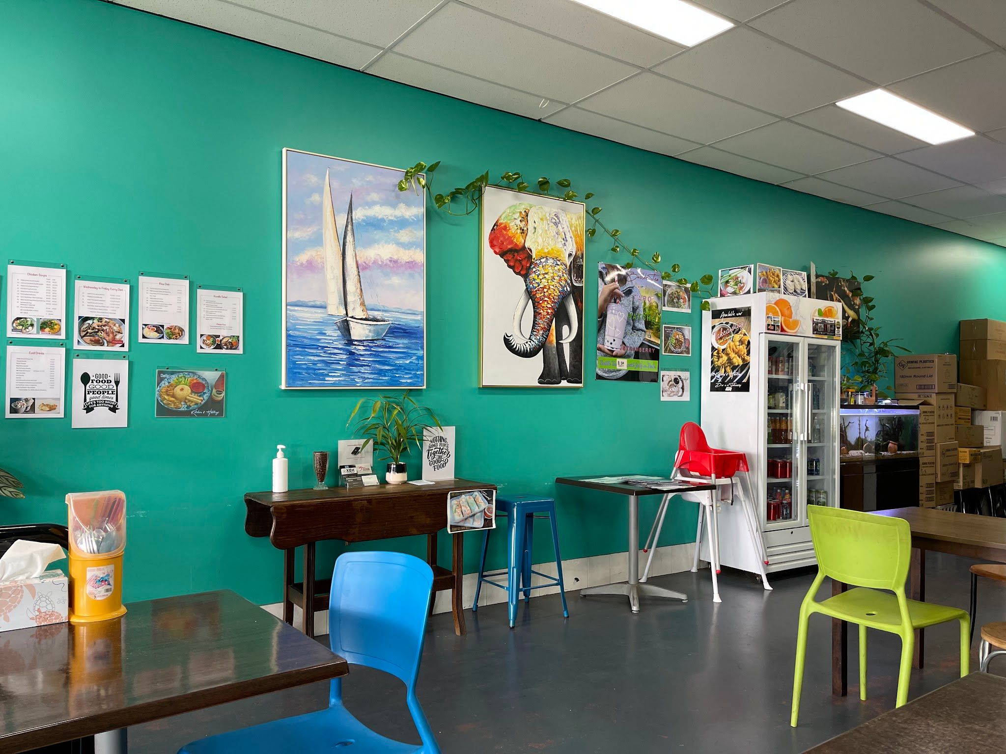 Kitchen 8 Hastings dining room wall with sailboat and elephant paintings and colourful chairs
